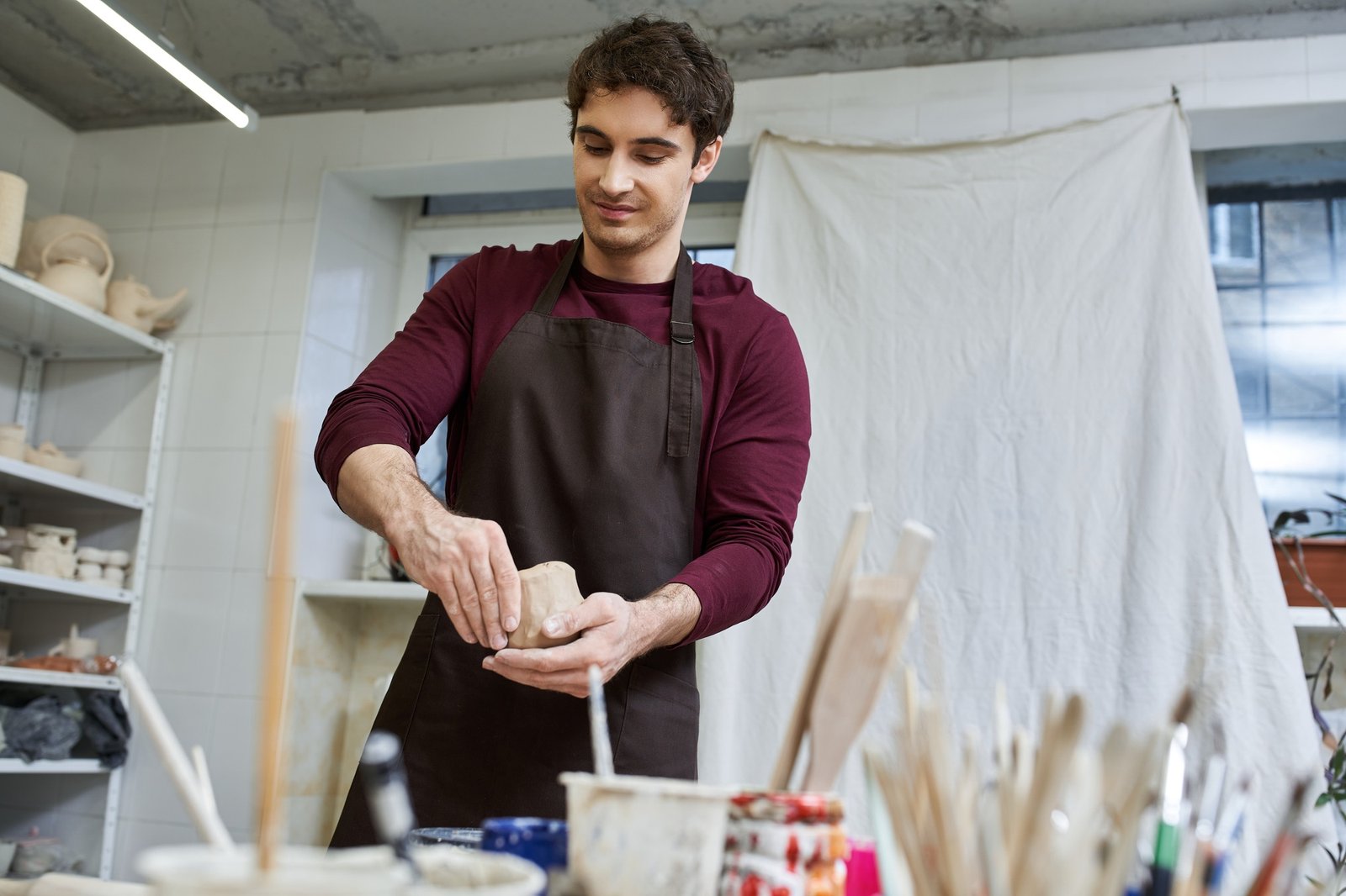 Joyful couple sharing creativity while making pottery together in a modern art studio